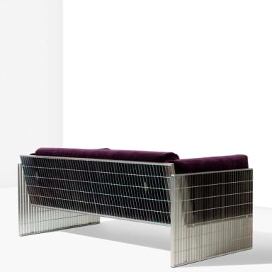 A modern sofa featuring a deep purple velvet upholstered seat and back, with rounded armrests. The frame and legs are constructed from polished metal, presenting a slatted design on the sides and base, giving it a distinct industrial or contemporary aesthetic. — 3D model