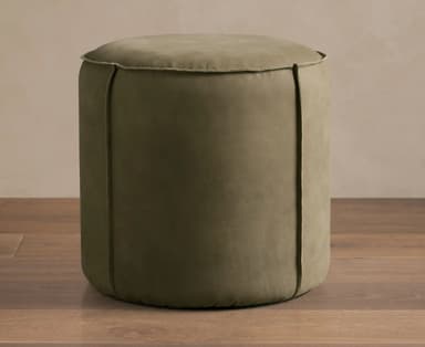 A low, cylindrical upholstered pouf in a muted olive green fabric with distinctive vertical seam details and a piped edge. — 3D model