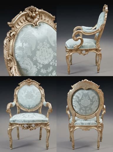A highly ornate, antique-style armchair featuring a carved, distressed giltwood or silver-leafed frame and light blue damask-patterned upholstery on the seat and oval-shaped backrest. The chair exhibits classic Rococo design elements, including cabriole legs, scrolled armrests, and elaborate foliate carvings along the frame. — 3D model