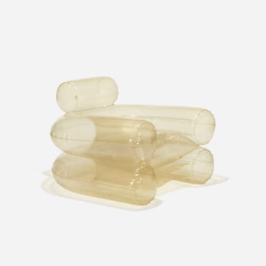 An inflatable armchair with a distinct translucent, smoky brown hue. The design features large, cylindrical forms for the armrests, base, and backrest, creating a plush and rounded silhouette. Seams are visible where the inflatable sections are joined, indicating its construction method. The material appears to be a flexible plastic or vinyl. — 3D model