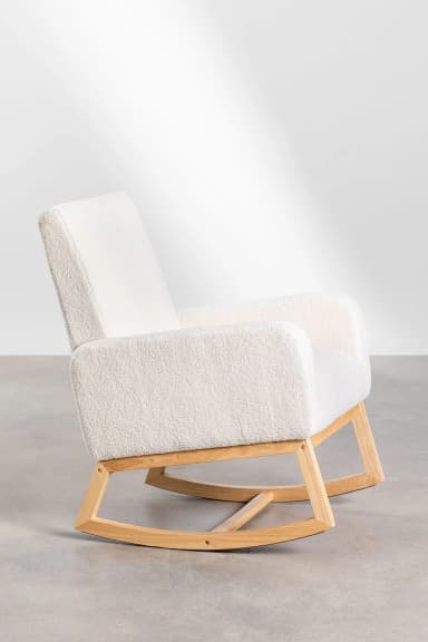 A rocking chair with a plush, textured upholstery and a natural wood frame. The chair features a high back, rounded armrests, and a curved base designed for rocking motion. The wood frame is visible beneath the upholstered seat and back, connecting the seat to the rocking base. — 3D model