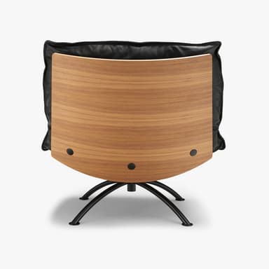 A modern lounge chair and matching ottoman featuring black leather upholstery, molded plywood shells, and black metal swivel bases with splayed legs. — 3D model