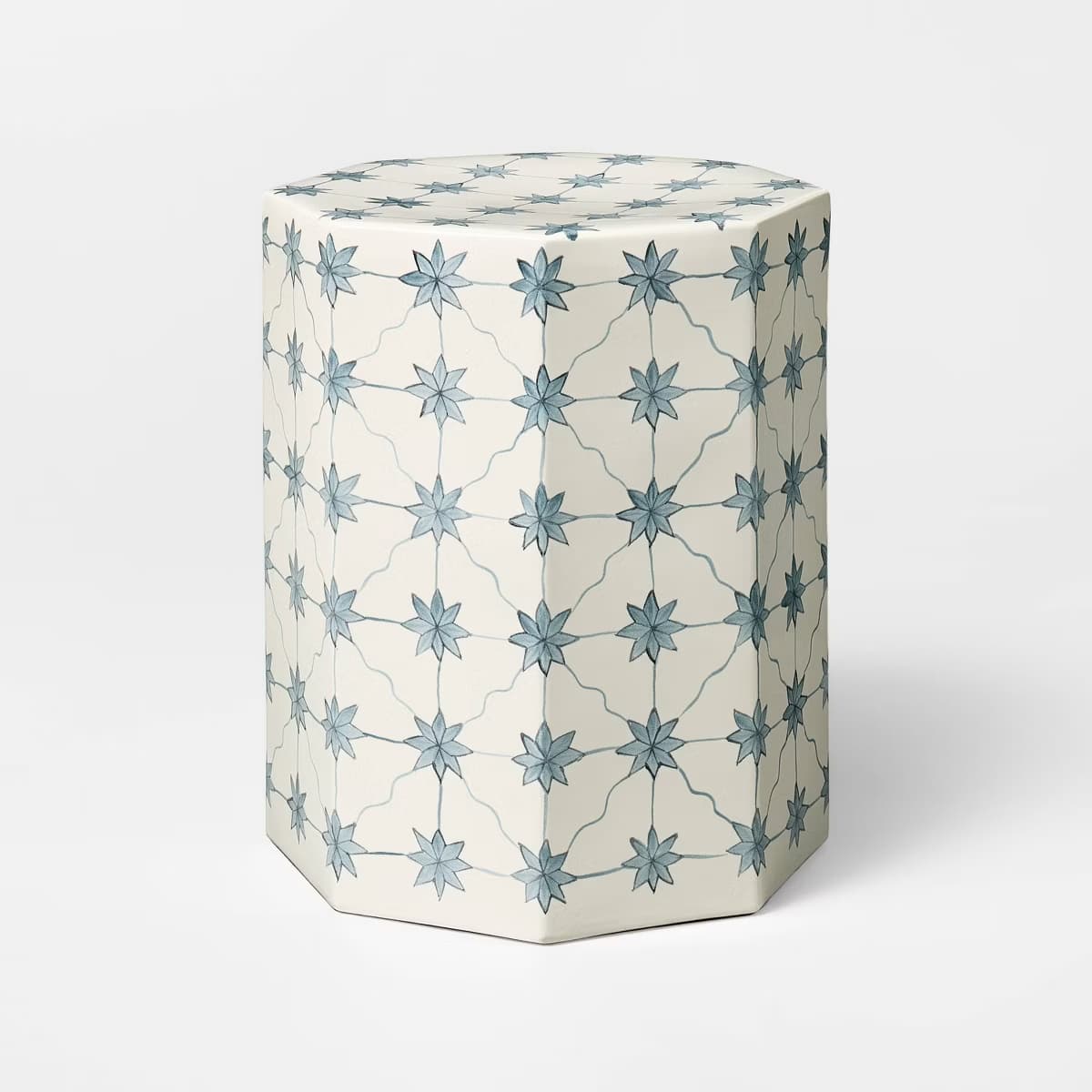 A hexagonal side table with a cream-colored base and a decorative pattern of light blue star-shaped flowers connected by thin, curved lines. The pattern covers the top surface and the sides of the table. — 3D model