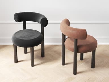 A contemporary accent chair featuring a circular upholstered seat and a continuous, rounded backrest that also functions as integrated armrests. The chair is supported by four dark, cylindrical wooden legs that extend directly from the seat frame. The upholstery is a soft, dark fabric in a consistent black color. — 3D model