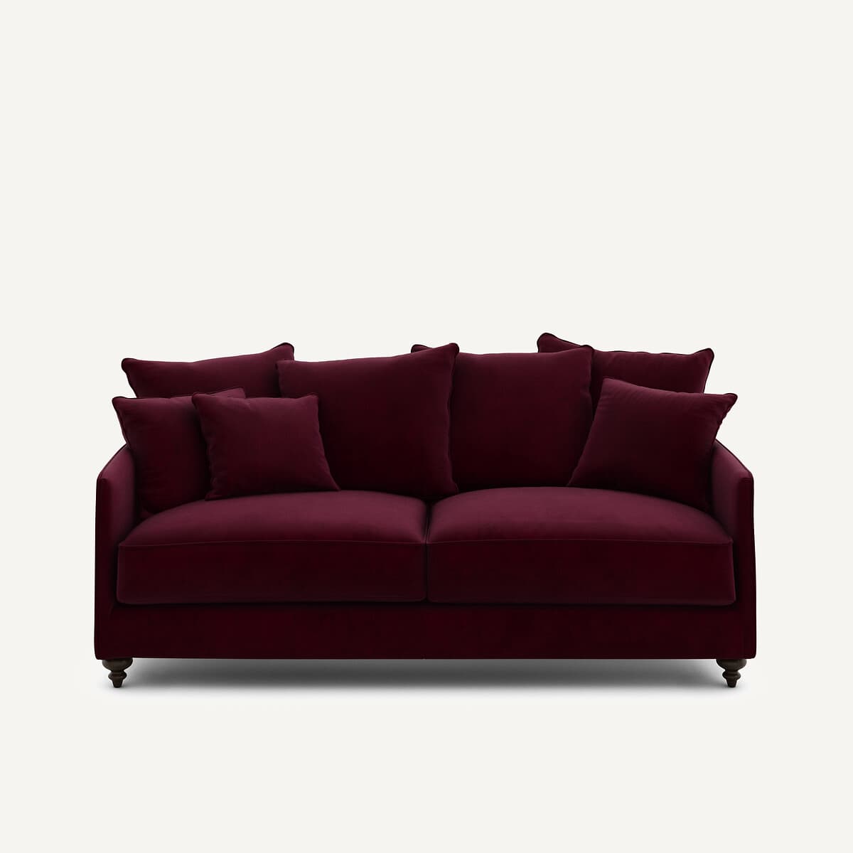 A deep burgundy velvet sofa with multiple loose back cushions and two seat cushions. The sofa has a modern yet classic design, featuring rolled arms and dark, turned wooden legs. The upholstery appears plush and soft to the touch, indicating a velvet material. — 3D model