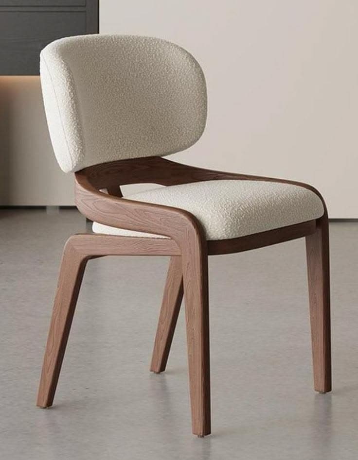 A modern dining chair featuring a gracefully curved wooden frame that elegantly supports both the upholstered seat and backrest. The seat and back are padded and covered in a light beige, textured boucle fabric, offering a soft contrast to the warm brown tone of the wood. The chair's design is sleek and contemporary, with the wooden legs flaring slightly outwards, enhancing its stability and aesthetic appeal. The integrated frame creates a seamless flow from the seat to the back support. — 3D model
