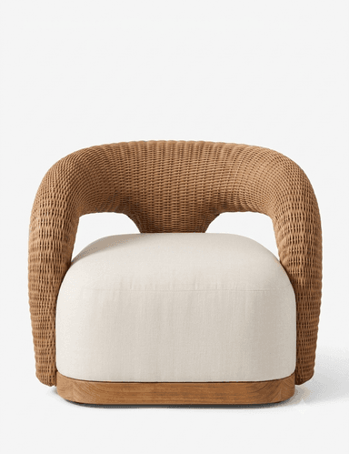 A contemporary armchair featuring a distinctive, continuous woven rattan frame that forms both the backrest and armrests. The seat consists of a thick, rounded, upholstered cushion, and the entire piece rests on a solid wooden plinth-style base. — 3D model