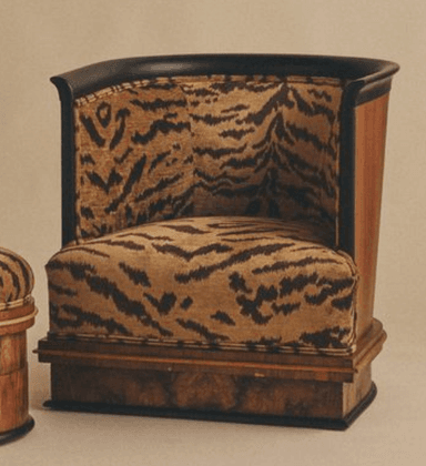 A barrel-shaped club chair upholstered in a striking tiger-stripe fabric, featuring a dark wood panel exterior with a sleek black trim. The base showcases a distinctive burled wood veneer. — 3D model