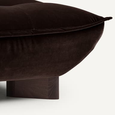 A low-profile, tufted sofa with a deep seat and a single, adjustable backrest. The sofa features a rounded front edge and is supported by dark, rectangular wooden legs. The upholstery appears to be a plush velvet fabric. — 3D model