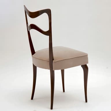 A side chair with a curved, open backrest and a padded seat. The frame and legs are made of dark wood, with a sculpted, organic form. The seat is upholstered in a light-colored fabric. — 3D model