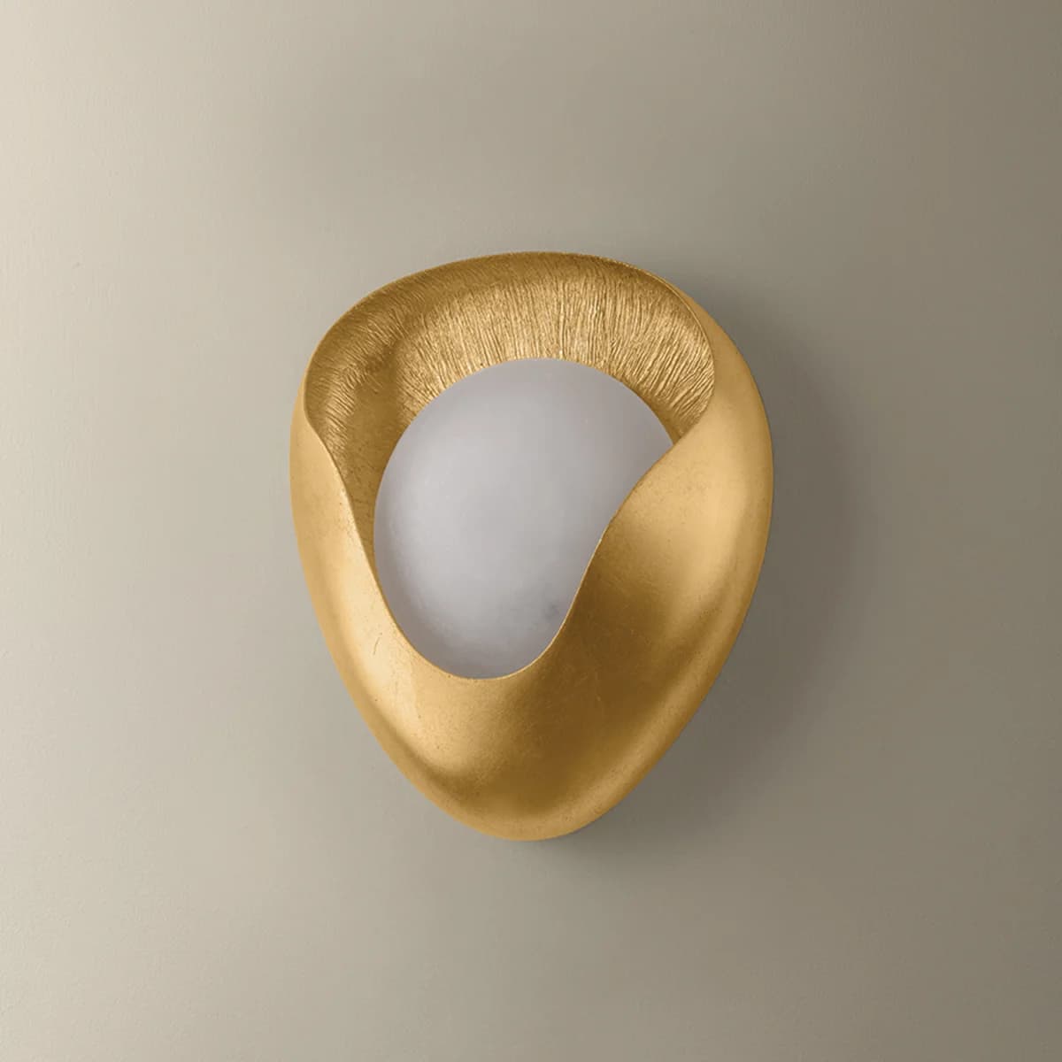 A modern, sculptural wall sconce featuring an abstract, organic shape with a textured gold finish, partially enclosing a spherical, frosted white light diffuser. — 3D model
