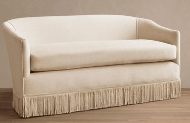 A contemporary loveseat upholstered in a light cream fabric, featuring a curved back, gently rolled armrests, a single seat cushion, and a distinctive decorative fringe skirt along the entire base. — 3D model