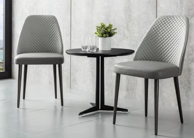 A modern black round side table with a minimalist design, featuring a circular top and a sturdy metal base with four legs connected by stretchers, rendered against a white background. — 3D model