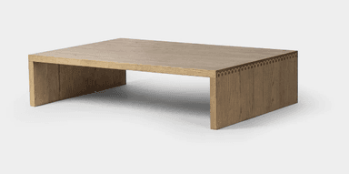 A rectangular coffee table constructed entirely from light-colored solid wood, featuring a minimalist slab design. The tabletop and legs form a continuous, block-like structure with visible wood grain. — 3D model