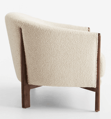 A two-seater loveseat featuring a curved back and integrated armrests, upholstered in a light-colored, textured boucle fabric. It is supported by a visible dark wood frame that extends from the base to form the armrests and partially the back structure. The loveseat rests on four short, solid wooden legs. — 3D model
