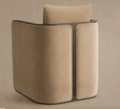 A modern armchair with a curved back and a separate headrest cushion. The armchair features a velour-like fabric upholstery in a neutral beige tone, contrasted with dark wood accents framing the back and sides. The wood elements appear to have a subtle grain pattern. The overall design suggests a contemporary or transitional style. — 3D model