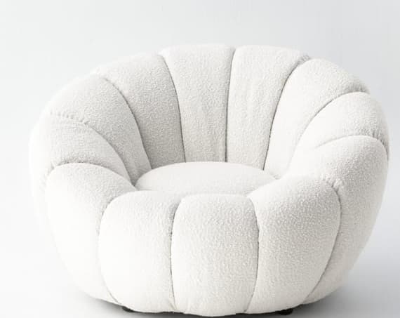 A low-profile, rounded lounge chair upholstered in a textured, off-white bouclé fabric. The chair features prominent vertical channel tufting that creates a scalloped or ribbed effect, forming the backrest, armrests, and base in a continuous, inviting shape. — 3D model
