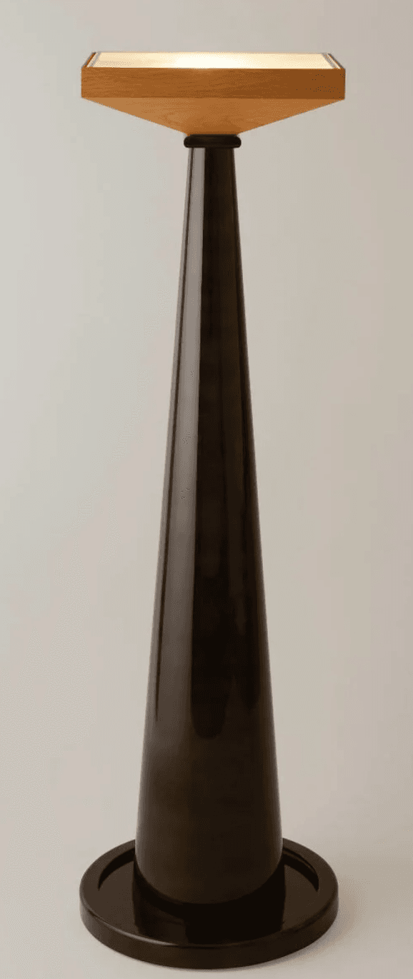 A tall, slender floor lamp featuring a dark, highly polished conical column and base, topped with a rectangular light-colored wooden shade or platform that emits a soft, diffused light. — 3D model