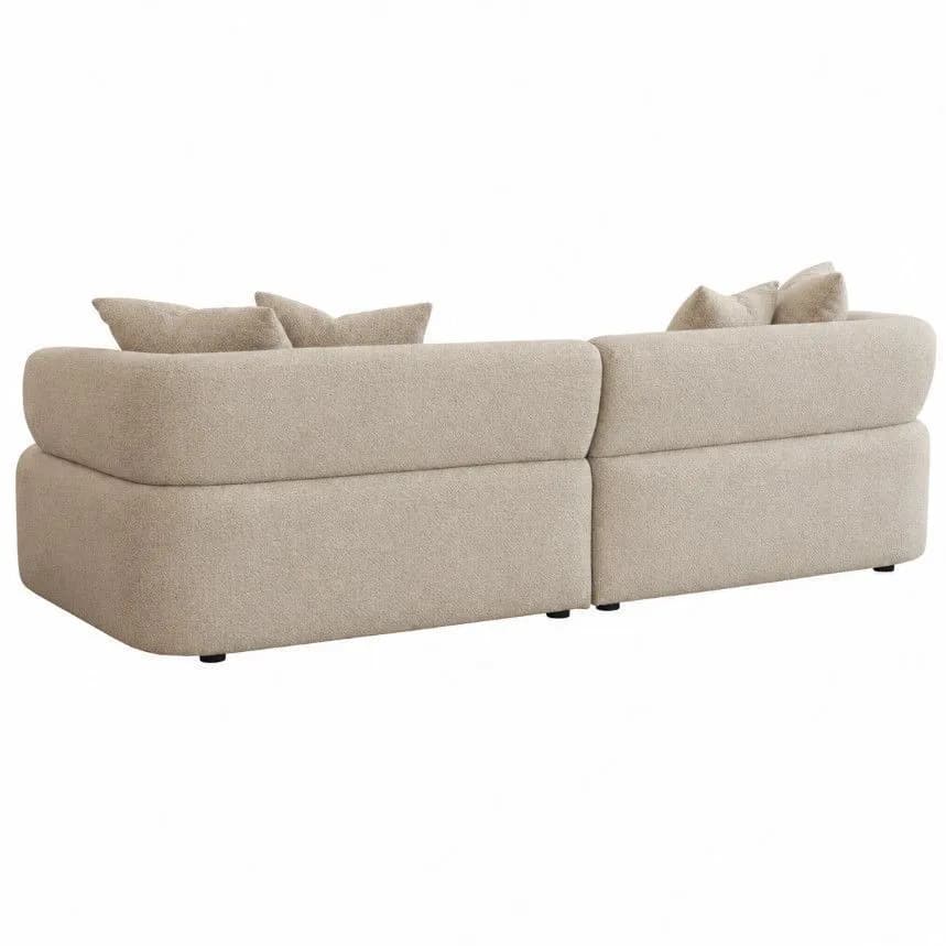 A contemporary modular sectional sofa upholstered in light beige bouclé fabric, featuring a low profile, rounded edges, and deep cushioning for a soft, inviting aesthetic. — 3D model