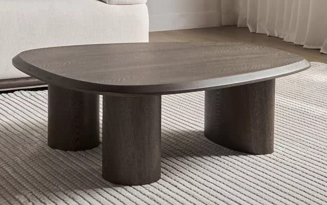 A dark stained wood coffee table featuring a rounded rectangular top supported by three thick cylindrical legs. — 3D model