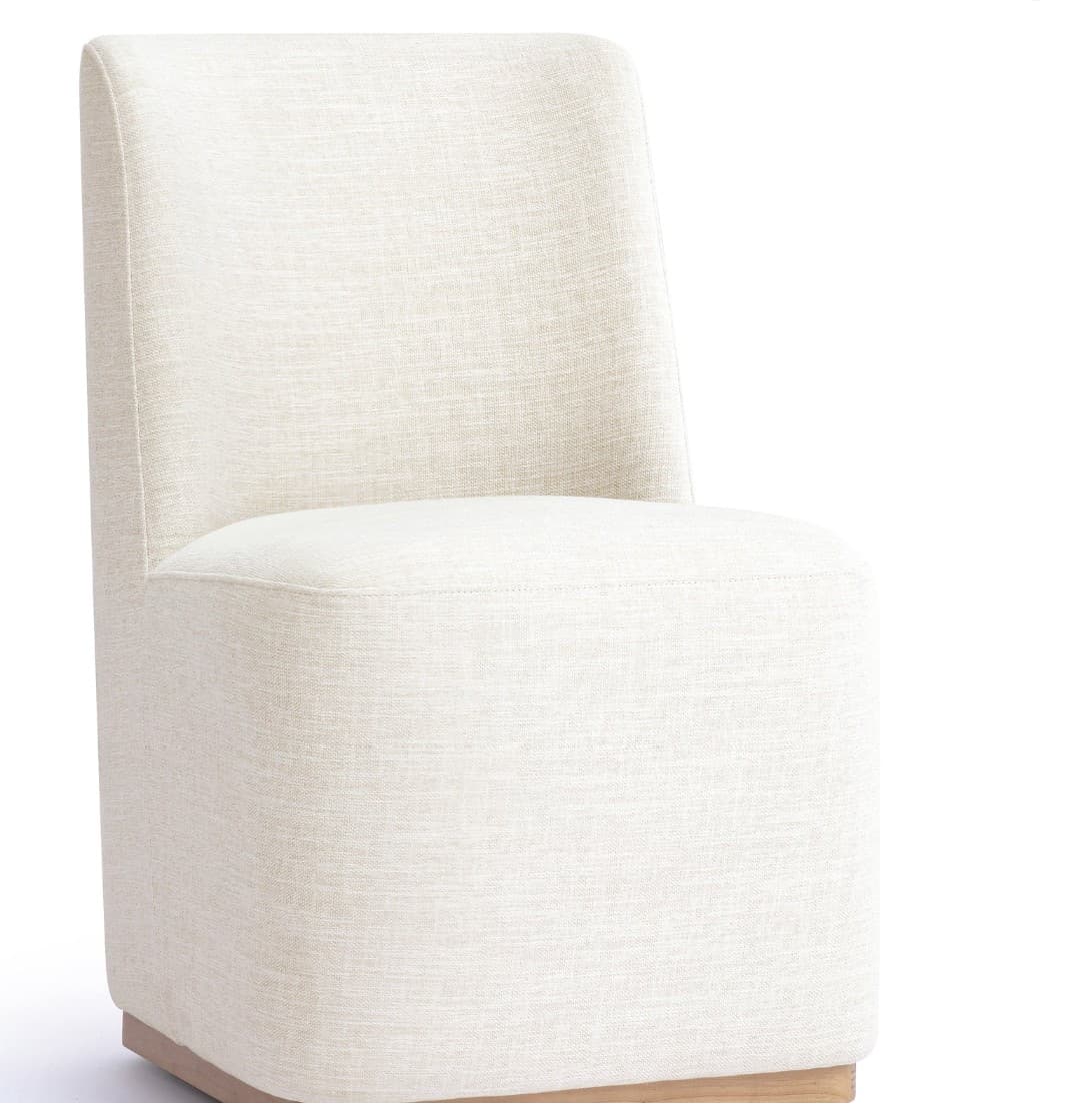 An armless, fully upholstered modern chair with a low back and a solid block-like base, featuring a light-toned textured fabric and a natural wood plinth. — 3D model