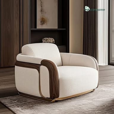 A contemporary upholstered armchair featuring a plush, rounded form. It showcases dark wood veneer accents along the outer armrests and back, complemented by subtle polished brass or gold-finished metal detailing near the base. The chair is upholstered in a light, textured cream or beige fabric, presenting a luxurious and inviting appearance. — 3D model