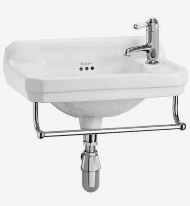 A white ceramic wall-mounted bathroom sink featuring an integrated chrome towel rail and a single-hole chrome mixer faucet with a white ceramic lever handle. The sink includes an exposed chrome P-trap and an overflow drain. The design is traditional, with stepped edges and a curved basin. — 3D model