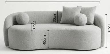 A contemporary, light gray boucle upholstered chaise lounge featuring a distinctive serpentine, curved silhouette. It has an integrated backrest and armrest on one side, flowing seamlessly into the base. The chaise comes with three matching boucle cushions: two square throw pillows and one spherical pillow, enhancing its soft and inviting aesthetic. — 3D model