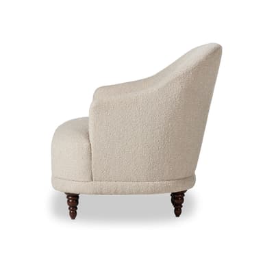 An upholstered barrel-back accent chair featuring a light-colored, textured boucle fabric, button tufting on the backrest, and four turned wooden legs. — 3D model