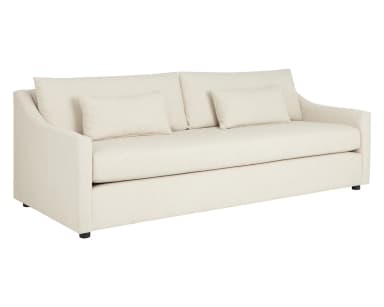 A contemporary sofa with a light-colored textured fabric upholstery. It features a deep seat, loose back cushions, and two accent pillows. The arms are gently sloped, and the sofa rests on short, dark-colored legs. — 3D model