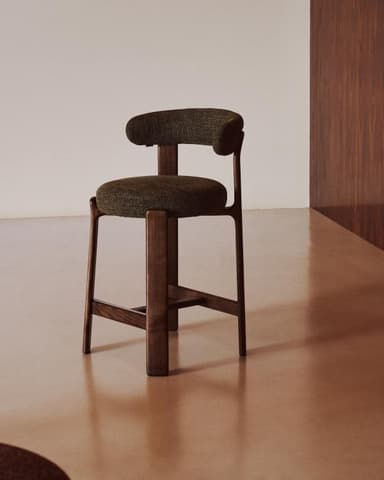 A modern bar stool with a dark wooden frame and a curved, upholstered seat and backrest in a textured green fabric. The frame consists of four legs connected by a crossbar, and the seat is round. The backrest is a semicircular shape that attaches to the rear legs. — 3D model