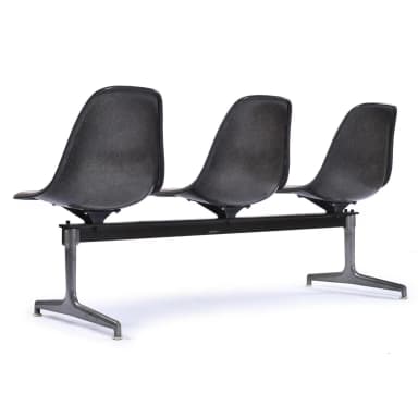 A three-seater bench with individual molded seats attached to a central metal frame. Each seat has a contoured ergonomic design and is upholstered in a tan material. The frame and legs appear to be made of dark metal, possibly cast aluminum or steel, with a stylized 'X' or pedestal base for each seat's support. — 3D model