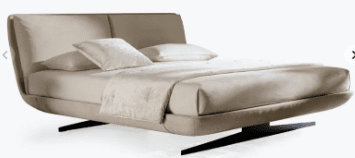 A modern bed frame with a curved, upholstered headboard and a low-profile base. The frame is supported by distinctive angled black legs. The bed is dressed with linens and pillows, including a textured throw blanket. — 3D model