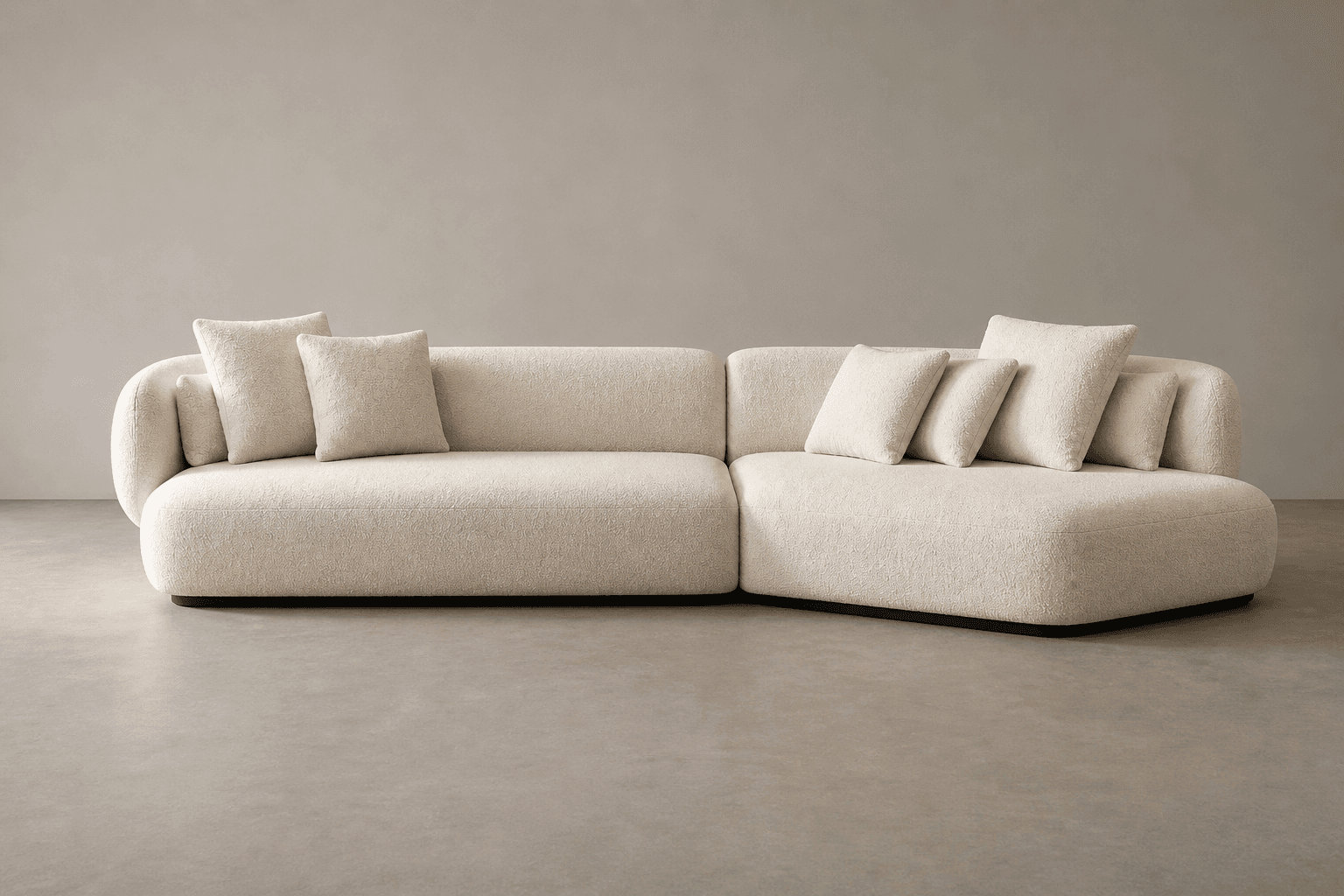 A sectional sofa with a low profile and rounded arms and back. The sofa is upholstered in a textured, boucle-like fabric in an off-white or cream color. It is accompanied by several throw pillows with a similar upholstery. The base of the sofa appears to be black. — 3D model