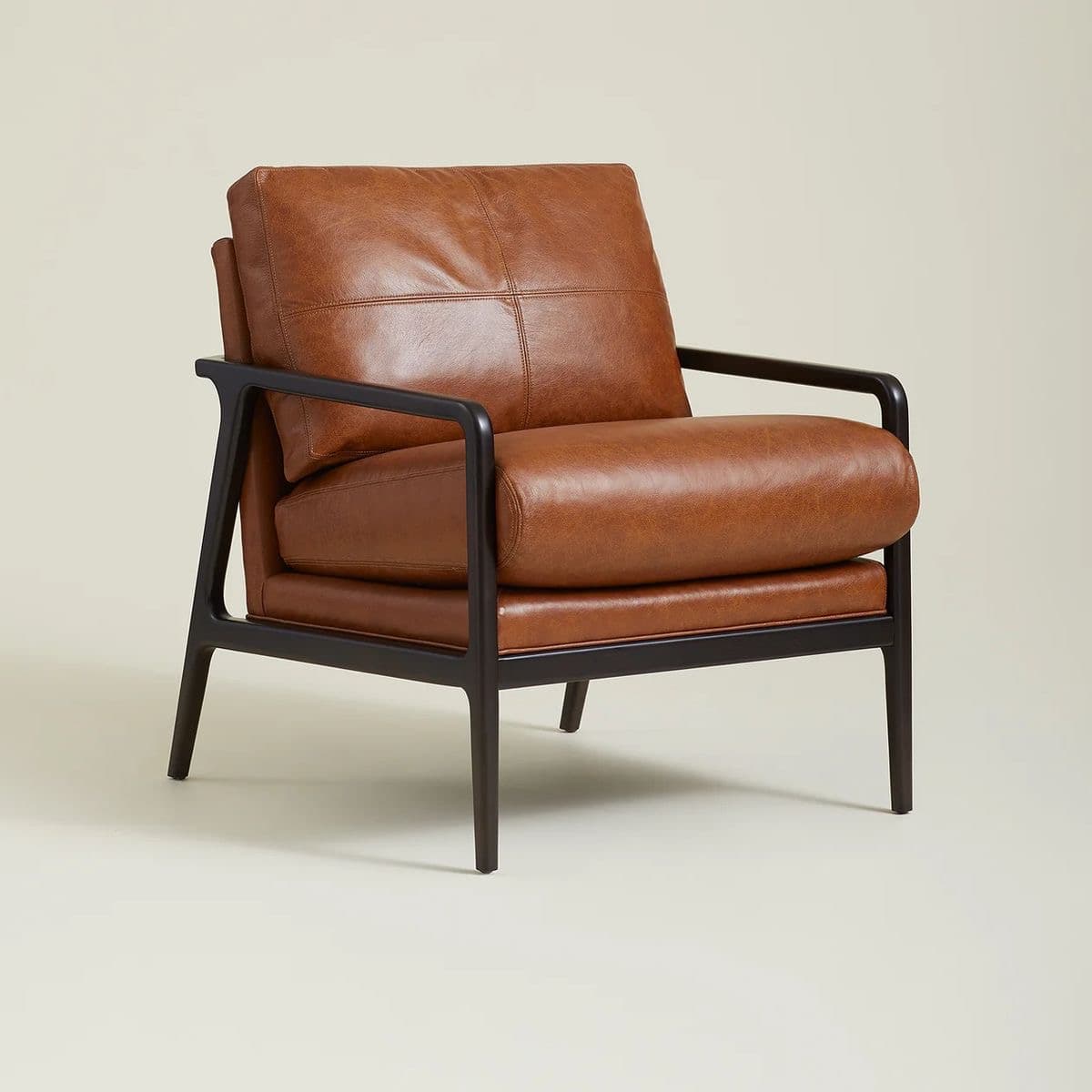 A contemporary armchair featuring a dark, possibly wood or metal, frame with sleek, straight lines. The seat and back cushions are upholstered in a rich, tan-colored leather with visible stitching detail, creating a segmented appearance on the back cushion. The armrests are integrated into the frame. — 3D model