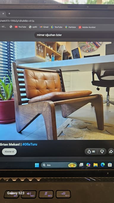 A modern low-profile lounge chair featuring a dark wooden frame with a slatted backrest and armrests, paired with thick, tufted brown leather cushions for the seat and back. — 3D model