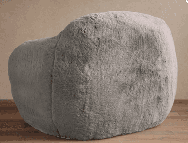 A plush, light gray faux fur lounge chair with a rounded and inviting silhouette. The chair features integrated, soft armrests and a contoured back, entirely covered in a shaggy, soft material. It appears to be a soft-filled design, resting directly on the floor without visible legs. — 3D model