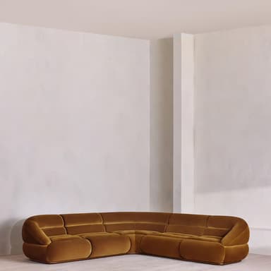 A modular sectional sofa with rounded edges and a plush velvet upholstery. The sofa is configured in a corner arrangement, featuring deep seats and back cushions with horizontal tufting. The design is low-profile and appears to be upholstered in a warm, mustard-yellow or ochre velvet fabric. — 3D model