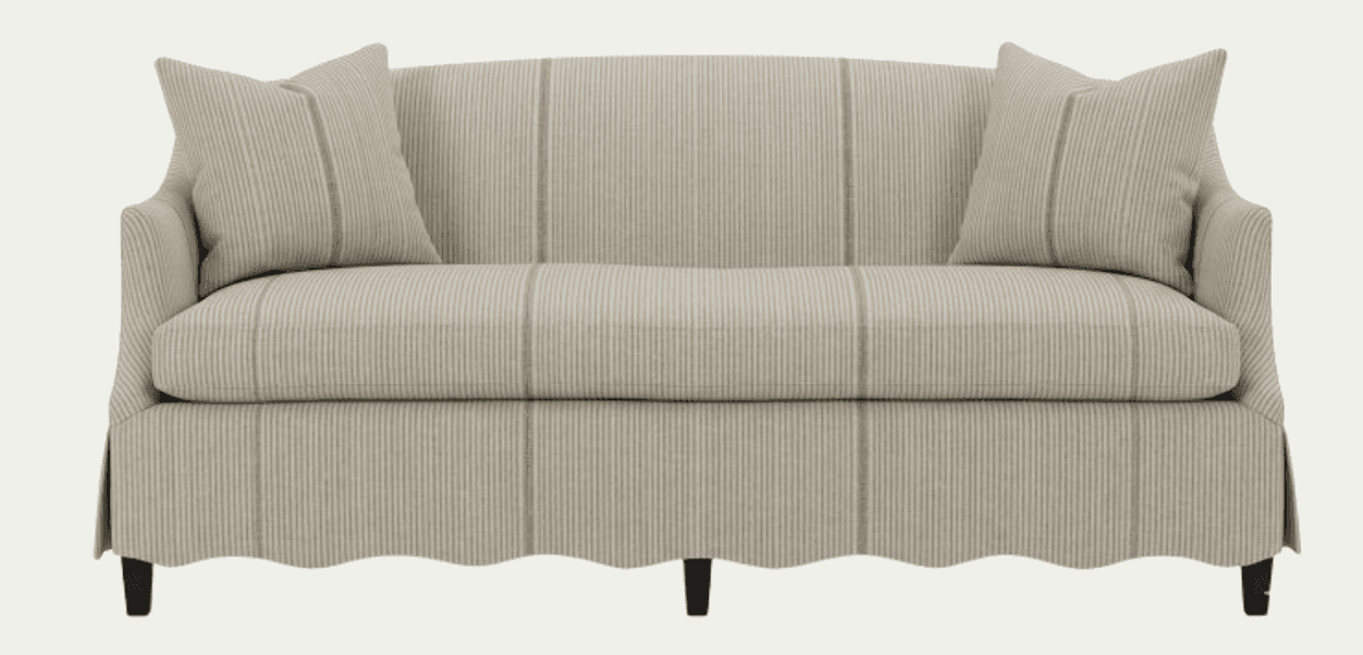 A sofa upholstered in a striped fabric with a scalloped bottom edge. It features two matching throw pillows placed on the arms. The sofa has a curved back and arms, and dark-colored legs. — 3D model