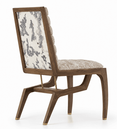A contemporary armchair with a sculpted wooden frame and upholstered seat and back. The backrest features horizontal ribbed detailing, and the seat is a cushioned expanse. The wooden frame has a distinctive angular design, particularly noticeable in the legs and the connection between the seat and back. Small brass accents are visible at the base of the legs and supporting the back frame. — 3D model