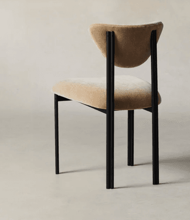 A modern dining chair featuring a matte black tubular metal frame and beige upholstered seat and sculpted backrest. — 3D model