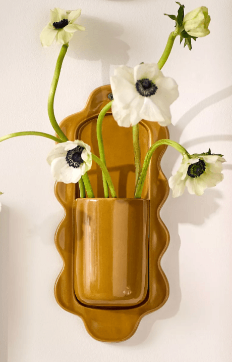 A small, wall-mounted shelf with a decorative scalloped edge. It features a cylindrical holder protruding from the front, designed for storage or display. — 3D model