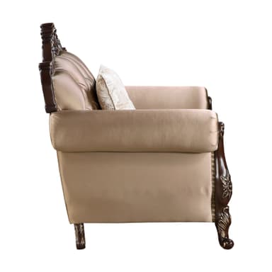An ornate single-seater armchair featuring a dark, richly carved wooden frame with gilded accents, and plush, light beige upholstered seating. The chair's design includes a prominent crest rail with intricate rococo-style carvings, scrolled armrests, and cabriole-style legs, all detailed with gold. The upholstery is secured by continuous brass nailhead trim along the edges. — 3D model