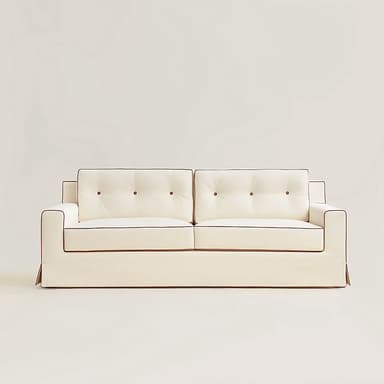 A white sofa with tufted back cushions and contrasting dark piping along the edges of the cushions and arms. The sofa features a skirted base and a clean, modern design. — 3D model
