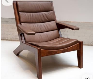This is a contemporary lounge chair featuring a sturdy dark wooden frame and comfortable brown leather-look upholstery. The design incorporates a slightly reclined back and a wide seat, complemented by padded armrests for enhanced comfort. The seat and backrest are composed of horizontal, channel-tufted cushions, creating a segmented appearance. The frame is constructed with visible wooden elements, including straight legs and angled supports, giving it a modern, yet timeless appeal. — 3D model