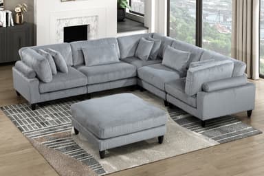A modern L-shaped sectional sofa upholstered in grey corduroy fabric. The sofa features a modular design with individual components forming a corner configuration. It includes multiple loose back cushions and additional throw pillows, all covered in the same ribbed corduroy material. The sofa rests on short, tapered black legs. — 3D model