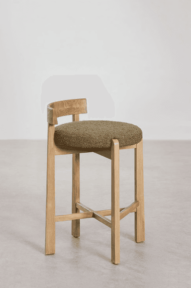 A modern counter stool crafted from light-toned oak wood, featuring a sturdy four-legged base with cross-stretchers for stability. The seat is a rounded, thick cushion upholstered in a textured, olive green bouclé fabric. A low, curved backrest is integrated into the rear legs, complementing the stool's contemporary design. — 3D model