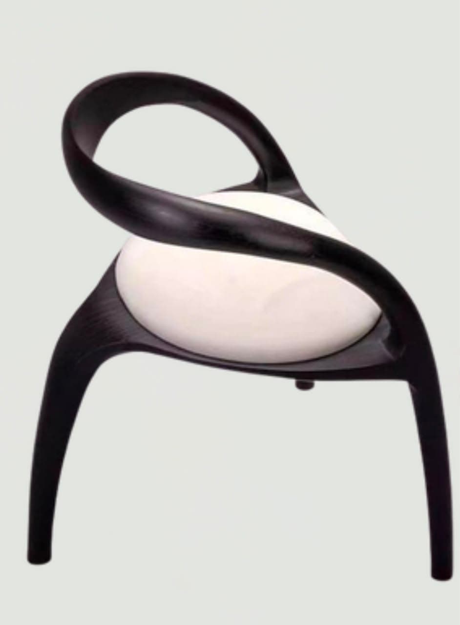 A contemporary armchair featuring a black, sculptural molded frame with integrated armrests and backrest, embracing a round white upholstered seat cushion. The chair has four splayed legs. — 3D model