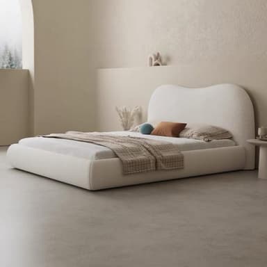 A modern upholstered platform bed featuring a soft, off-white bouclé fabric covering and a distinctive sculpted, organic-shaped headboard. The bed frame itself is also upholstered, creating a seamless, plush appearance. — 3D model