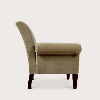 A fully upholstered armchair featuring distinct rolled arms and exposed dark wooden legs. The chair is covered in a soft, plush fabric, likely velvet or velour, in a muted, light greenish-beige color. Its back is gently reclined, and the seat appears well-cushioned, suggesting comfort. The legs are tapered and rectangular. — 3D model